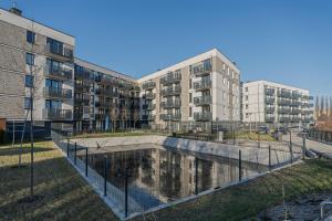 an apartment complex with a pool in front of a building at Azure Mostek Oldtown in Gdańsk