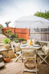 a table and chairs under an umbrella on a deck at No61 Winchcombe (Cotswolds) in Winchcombe