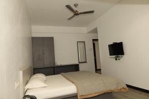 a bedroom with a bed with a ceiling fan at Anusha Hotel in Nashik