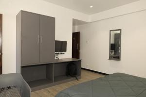 a bedroom with a bed and a cabinet with a television at Anusha Hotel in Nashik