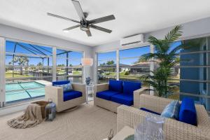 a living room with blue furniture and a pool at Waterfront Oasis in Cape Coral