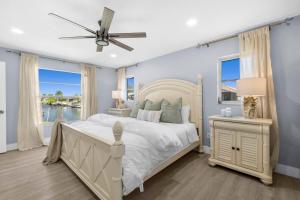 a bedroom with a large white bed and a window at Waterfront Oasis in Cape Coral