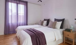 two beds in a white room with purple curtains at Villa Fratello in Baku +19 photos