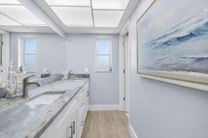a bathroom with two sinks and a painting on the wall at Waterfront Oasis in Cape Coral +26 photos