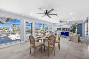 a dining room with a ceiling fan and a table and chairs at Waterfront Oasis in Cape Coral