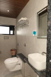a bathroom with a white toilet and a sink at Anusha Hotel in Nashik +12 photos