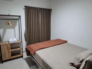 a small bedroom with a bed and a mirror at Ndalem Livtuhayu in Godean
