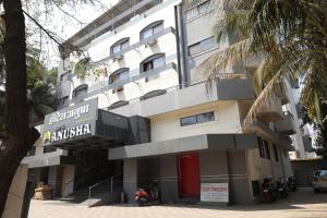 a large white building with a sign on it at Anusha Hotel in Nashik