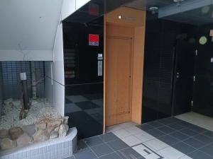 an entrance to a building with a brown door at ゲストハウス瓦町 in Takamatsu +41 photos