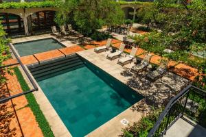 an overhead view of a swimming pool with lounge chairs at Hotel Boutique Las Hortensias in Pilar