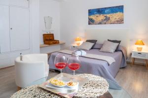 a bedroom with a bed and two glasses of wine at Belvedere del Lago in Montefiascone