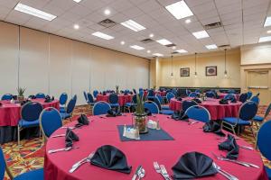 a banquet hall with red tables and blue chairs at Clarion Hotel Conference Center Lexington North in Lexington +162 photos