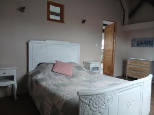 a bedroom with a bed with a pink pillow on it at La cabane de Lancelot Loubliette in Laperrière-sur-Saône