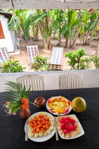 a table with two plates of fruit on it at Solar House Hotel in Dickwella +76 photos
