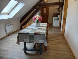 a dining room table with a vase of flowers on it at La cabane de Lancelot Loubliette in Laperrière-sur-Saône