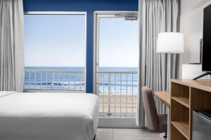 a hotel room with a bed and a view of the ocean at Spark by Hilton Virginia Beach Oceanfront in Virginia Beach
