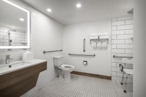 a white bathroom with a toilet and a sink at Spark by Hilton Virginia Beach Oceanfront in Virginia Beach +13 photos