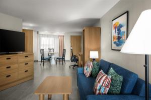 a living room with a blue couch and a table at Home2 Suites by Hilton Outer Banks Kill Devil Hills in Kill Devil Hills