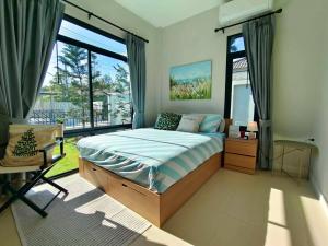 a bedroom with a bed and a large window at Mango Villa แมงโก้ วิลล่า in Sa Kaeo