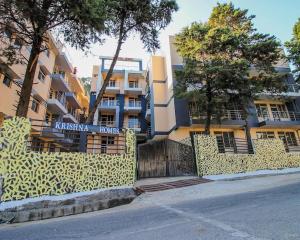 a large building with a fence in front of it at Premium 2BHK near Kainchi Dham in Bhowāli