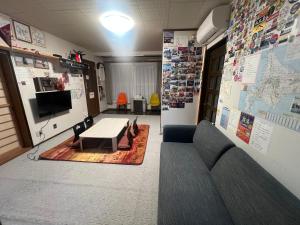a room with a couch and a table and a tv at 旭川ロキ in Asahikawa