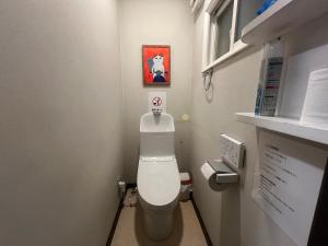 a bathroom with a toilet with a sign above it at 旭川ロキ in Asahikawa