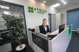 a woman sitting at a reception desk in an office at 4 TREES Airport Resort Apartments and Rooms in Velika Gorica +80 photos