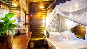 a bedroom with a canopy bed with white pillows at Cozora Nook - Sigiriya in Sigiriya