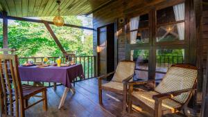 a dining room with a table and chairs on a porch at Cozora Nook - Sigiriya in Sigiriya
