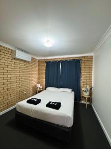 a bedroom with a bed with two black towels on it at Ocean View Villas in Geraldton +28 photos