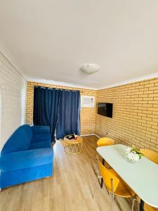 a living room with a blue couch and a table at Ocean View Villas in Geraldton