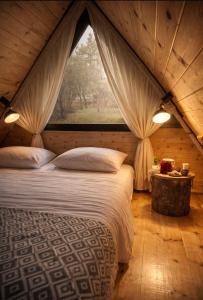 a bedroom with a large bed with a window at Tasia's Cottage in Tsalka