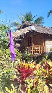a house with a purple flag in front of it at Bamboo Basecamp in El Nido