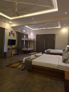 a bedroom with two beds and a flat screen tv at Miransh Heavenly in Dapoli