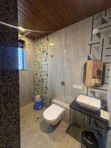 a bathroom with a toilet and a sink and a mirror at Miransh Heavenly in Dapoli +17 photos