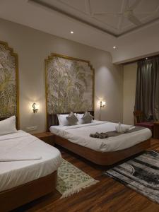 a bedroom with two beds and a painting on the wall at Miransh Heavenly in Dapoli