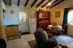a kitchen with a table and a white refrigerator at Curtis Cottage in Mount Tamborine