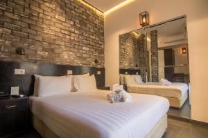 a hotel room with two beds and a brick wall at Bell Boutique and Spa Hotel in Tel Aviv