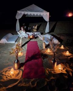 a table with candles and a red table cloth at Royal Salma Resort A family Luxury Camp 