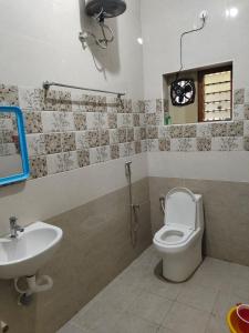 a bathroom with a toilet and a sink at HAnsHari Homestay in Kuttālam