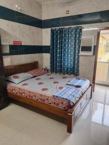 a bedroom with a bed with a curtain and a window at HAnsHari Homestay in Kuttālam