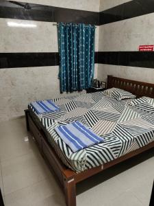 a bed with blue and white pillows on it at HAnsHari Homestay in Kuttālam +7 photos