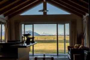 a living room with a large window with a view of the mountains at Omahau Down in Lake Pukaki