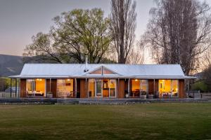 a house with a metal roof on a grass field at Omahau Down in Lake Pukaki