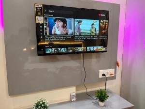 a flat screen tv hanging on a wall at Quantum stay 1 BHK couples family corporate in Noida
