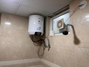 a shower in a bathroom with a shower head at Quantum stay 1 BHK couples family corporate in Noida +6 photos