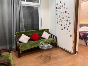 a living room with a green couch and a wall with a climbing wall at Quantum stay 1 BHK couples family corporate in Noida