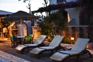 a group of chairs and tables in a patio at Holiday Beach Resort Santorini in Perivolos