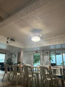a dining room with tables and chairs and a chandelier at En Pensionne, Lodging in Iloilo City