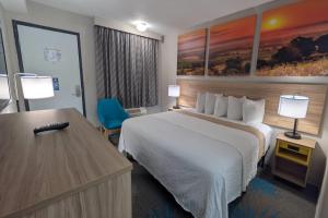 a hotel room with a large bed and a desk at Days Inn by Wyndham Champaign/Urbana in Champaign